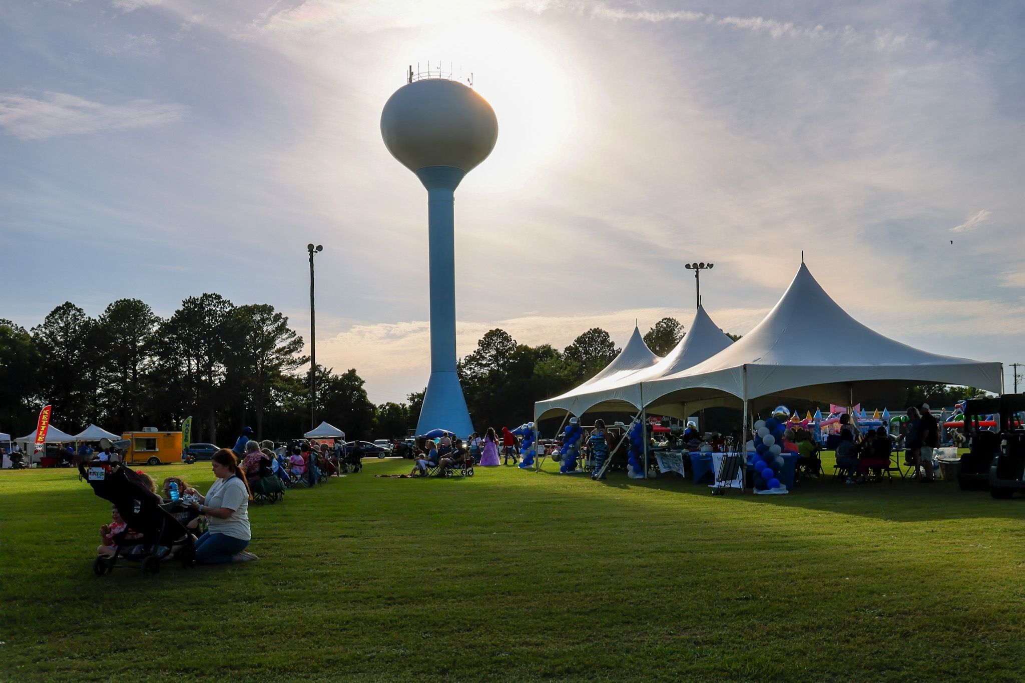 Warner Robins community festival beneath the water tower in warm evening light